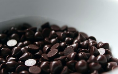 Dark bitter chocolate chips in the shape of drops, for cooking pastry or use in food decor.