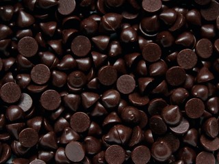 Dark bitter chocolate chips in the shape of drops, for cooking pastry or use in food decor.