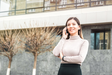 young attractive and confident business woman speaking on the phone in front of business center