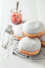 Sweet donuts with white icing on white table