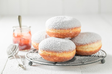 Obraz na płótnie Canvas Closeup of tasty donuts with powdered sugar on white table