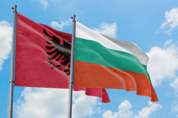 Bulgaria and Albania flags waving in the wind against white cloudy blue sky together. Diplomacy concept, international relations.