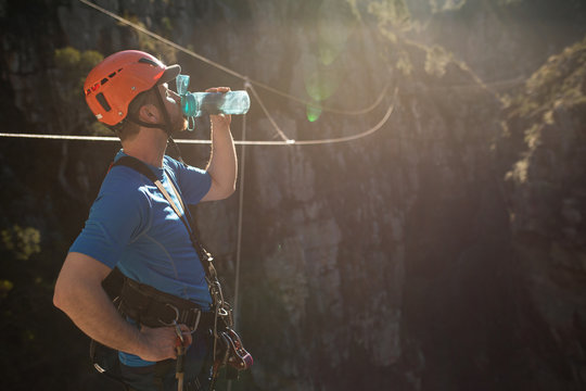 Caucasian man drinking before zip line - Powered by Adobe
