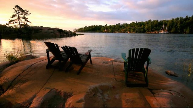 Muskoka chairs on rock beach in cottage country in Georgian Bay, Ontario, Canada