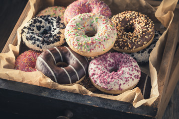 Closeup of tasty donuts in old wooden boxes - obrazy, fototapety, plakaty