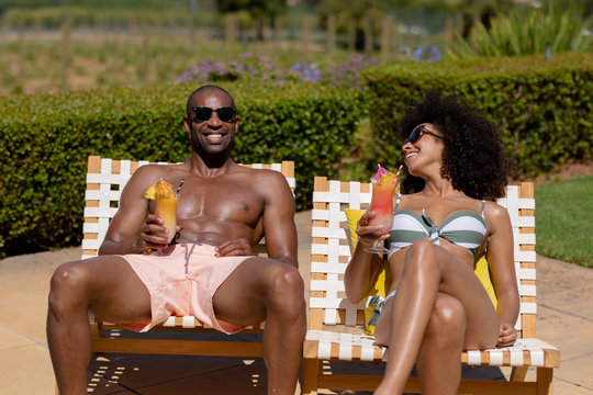 Young couple relaxing near swimming pool on a sunny day