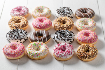 Donuts with various types of toppings on white table