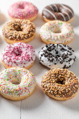 Closeup of donuts with toppings on white table