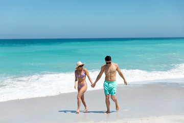 Young couple walking besides the beach