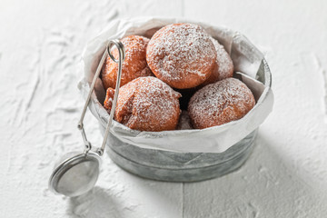 Donuts balls with powdered sugar on white table