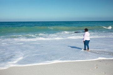 Old woman walking at the beach