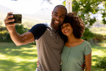 Happy young couple taking selfie in the garden