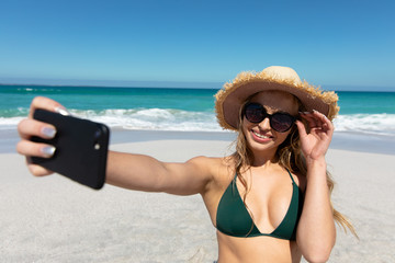 Young woman taking selfies at the beach