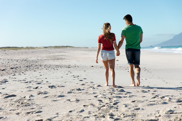 Rear view young couple holding hands