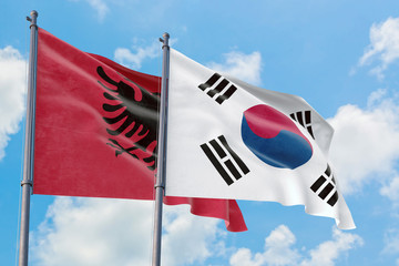 South Korea and Albania flags waving in the wind against white cloudy blue sky together. Diplomacy concept, international relations.