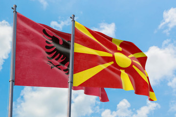 Macedonia and Albania flags waving in the wind against white cloudy blue sky together. Diplomacy concept, international relations.