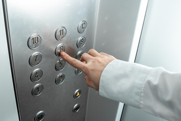 Female hand, finger presses the elevator button. up the career ladder. © Aliaksandr Marko
