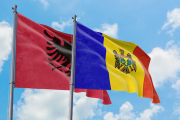 Moldova and Albania flags waving in the wind against white cloudy blue sky together. Diplomacy concept, international relations.