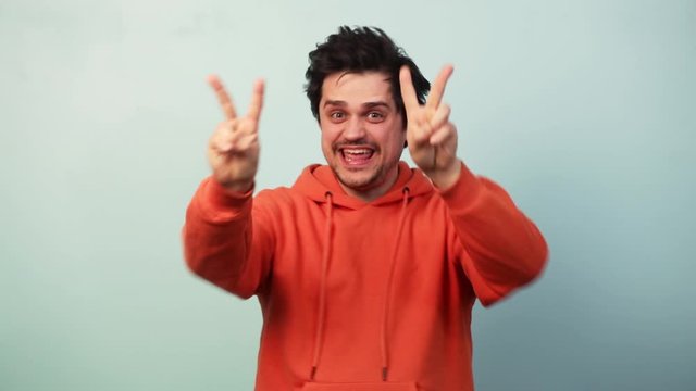 Guy show approval gesture on blue background
