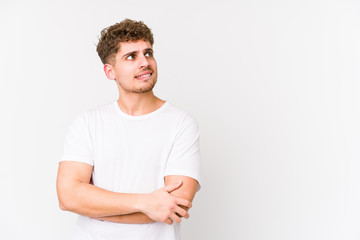 Young blond curly hair caucasian man isolated relaxed thinking about something looking at a copy space.