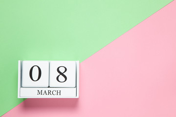 Perpetual calendar with date of March 8 on two-color background pink and green. Flat lay. Top view. International Happy Women's Day celebration concept. Horizontal, close-up, copy spase. For delivery