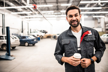 Mechanic with a paper cup posing for the camera