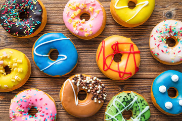 Various colorful donuts on wooden