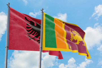 Sri Lanka and Albania flags waving in the wind against white cloudy blue sky together. Diplomacy concept, international relations.