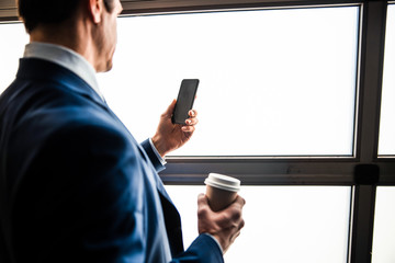 Businessman holding a paper cup of beverage
