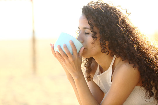 Latin Girl Drinking Coffee On The Beach