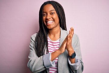 Young african american business woman standing over pink isolated background clapping and...
