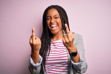 Young african american business woman standing over pink isolated background Showing middle finger...