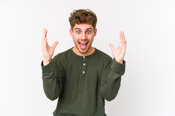 Young blond curly hair caucasian man isolated receiving a pleasant surprise, excited and raising hands.