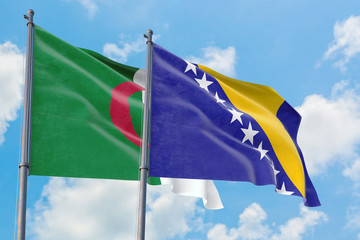 Bosnia Herzegovina and Algeria flags waving in the wind against white cloudy blue sky together. Diplomacy concept, international relations.