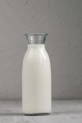 Milk in white glass bottle  isolated on grey background, top view and empty space for text