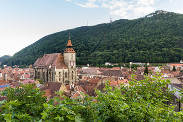 Panoramic view of Brasov old town and Black Church with the Carpathian Mountains in a spring day, Transylvania, Romania.