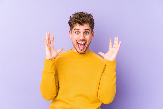 Young blond curly hair caucasian man isolated celebrating a victory or success, he is surprised and shocked.