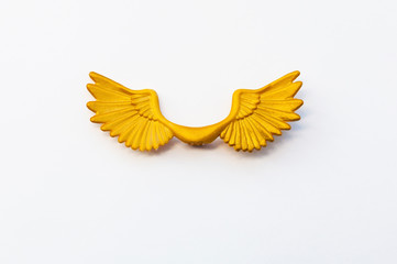 Beautiful golden plastic wings on a white background with place for text.