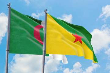 French Guiana and Algeria flags waving in the wind against white cloudy blue sky together. Diplomacy concept, international relations.