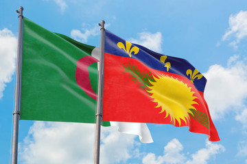 Guadeloupe and Algeria flags waving in the wind against white cloudy blue sky together. Diplomacy concept, international relations.