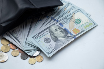 American dollars on a white background. One hundred dollar bills. Coins on the table. I put money...
