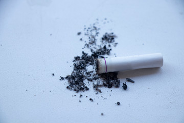 Nicotine addiction - stop killing yourself. Fist on cigarette butts. Broken cigarette in the hands. Stop.