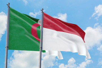 Indonesia and Algeria flags waving in the wind against white cloudy blue sky together. Diplomacy concept, international relations.