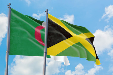 Jamaica and Algeria flags waving in the wind against white cloudy blue sky together. Diplomacy concept, international relations.