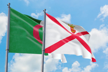 Jersey and Algeria flags waving in the wind against white cloudy blue sky together. Diplomacy concept, international relations.