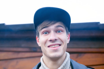 Portrait of a young happy guy 20-21 years old in a cap