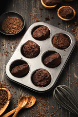 Cupcakes, muffins in a baking pan on a black table. Cupcakes, muffins on a wooden board and a black wooden table. Fresh French Baked Cupcakes. Warm Fresh Buttery Rolls