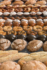 Different kinds of fresh bread on a table. Assortment of fresh bakery products on wooden table.