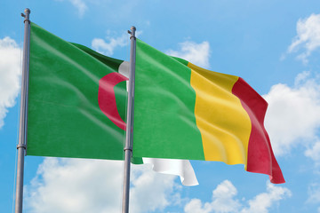 Mali and Algeria flags waving in the wind against white cloudy blue sky together. Diplomacy concept, international relations.