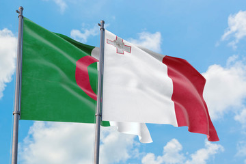 Malta and Algeria flags waving in the wind against white cloudy blue sky together. Diplomacy concept, international relations.